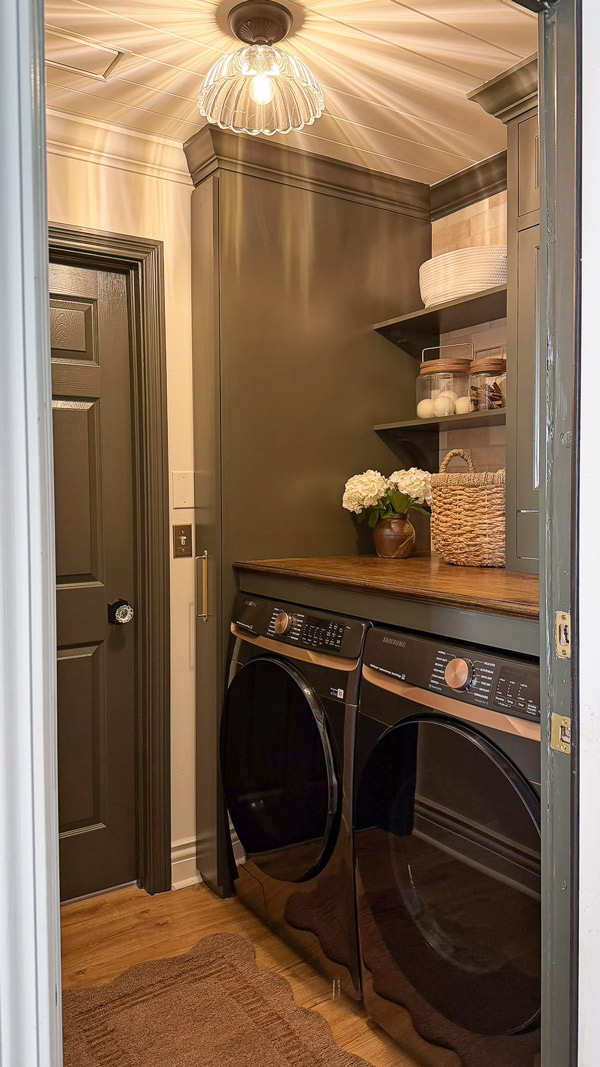 small laundry room makeover before and after ith wood countertop over washer and dryer, wood shelves, and broom cabinet