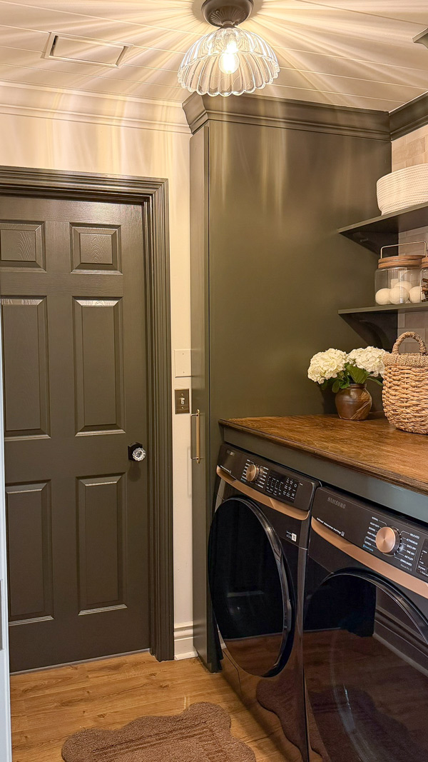 small laundry room makeover before and after with green cabinets and with wood countertop over washer and dryer, wood shelves, and broom cabinet