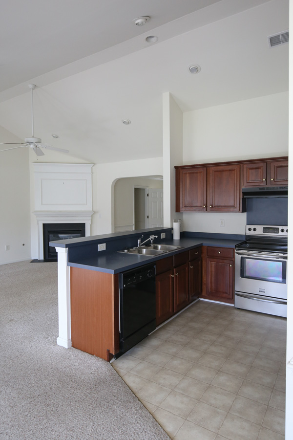before living room and kitchen makeover - builder grade and stained white carpet and white walls